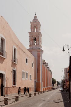 View of a historic tower and street in Puebla, Mexico showcasing colonial architecture.
