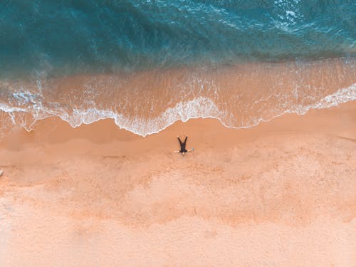 Free Man Lying Down on Beach Stock Photo