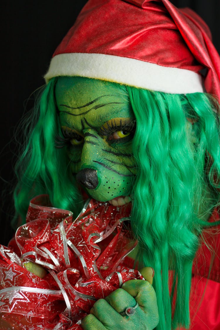 Woman In A Grinch Costume With A Santa Hat 