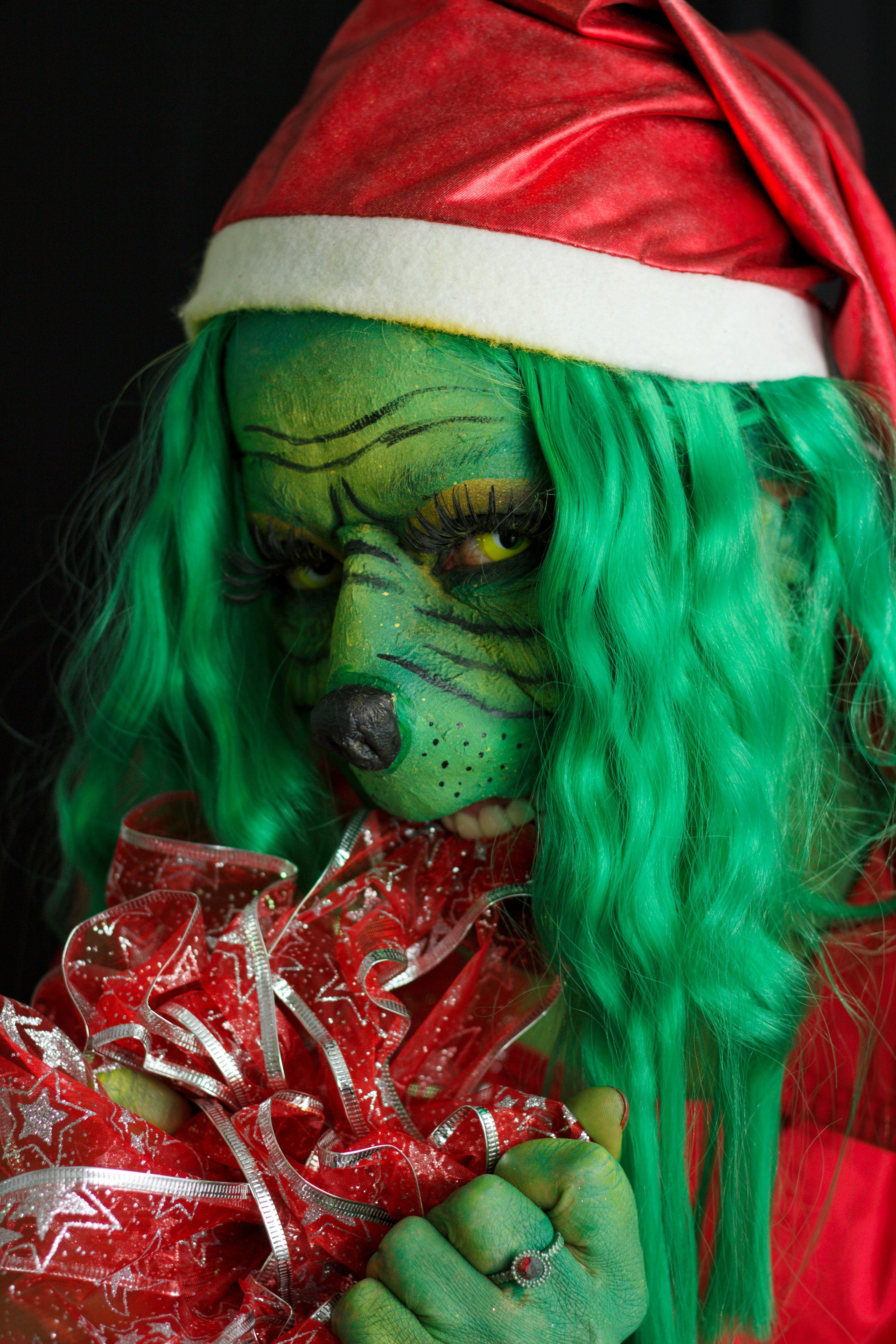 Woman in a Grinch Costume with a Santa Hat  Free Stock Photo