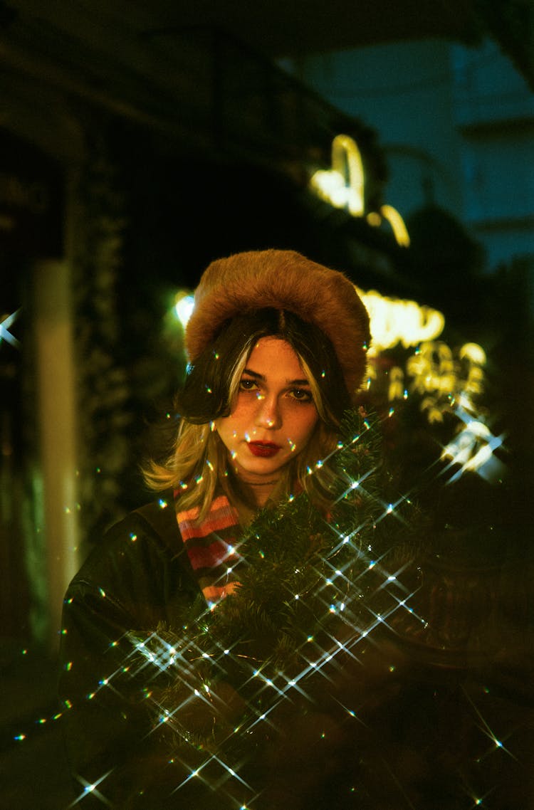 Woman In A Hat Standing Outside And Holding Christmas Lights 