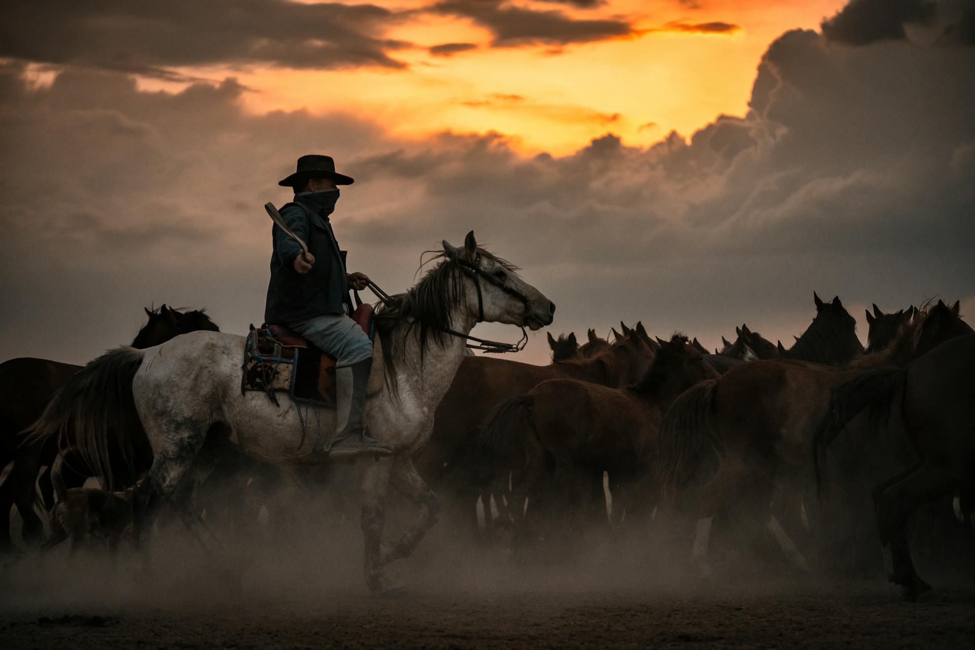 Cowboy in a Scarf Riding a Horse Leading the Herd