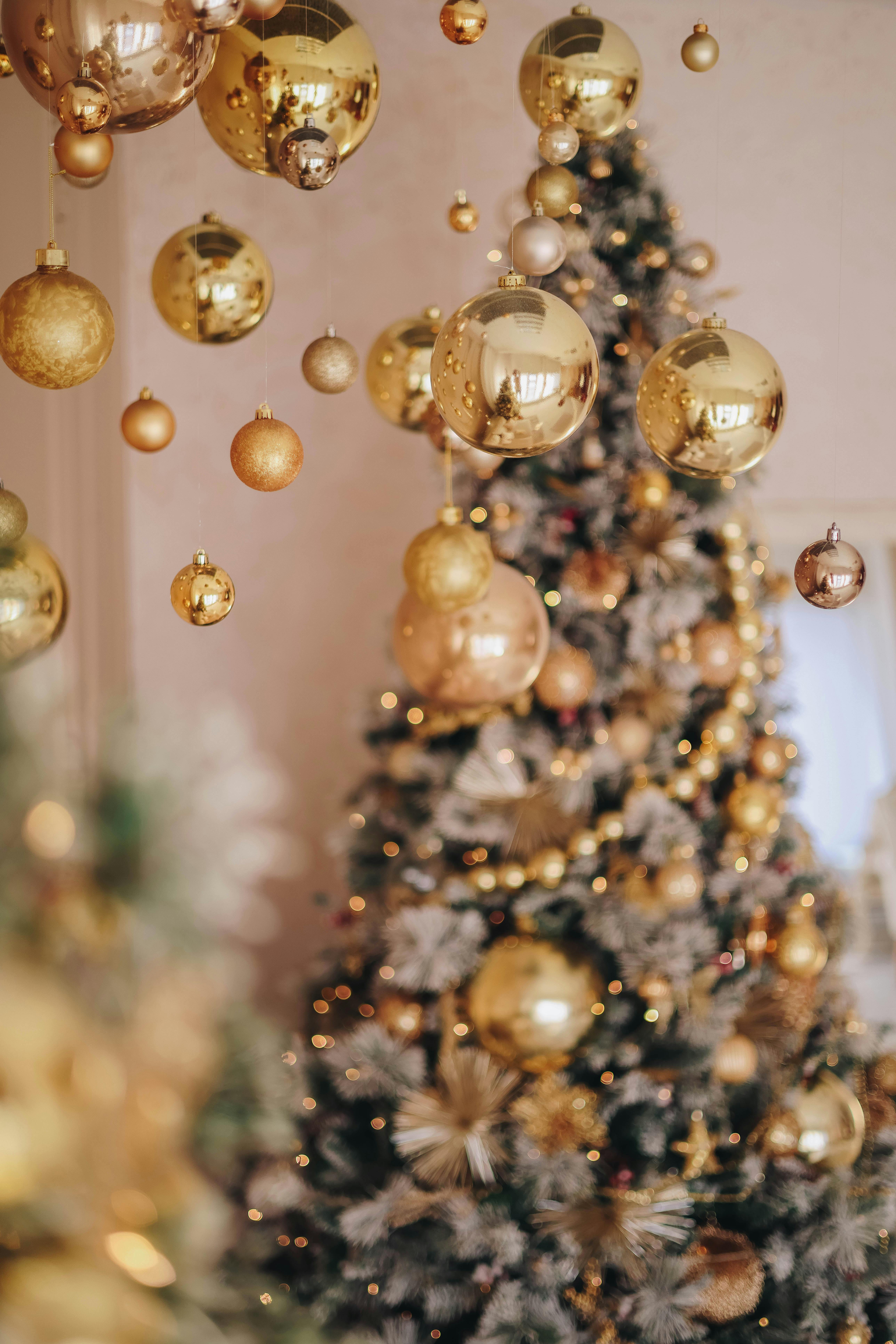 Beautifully decorated Christmas tree with gold baubles and soft lighting, perfect for festive ambiance.