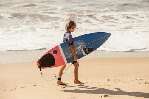 Boy on Beach with Surfboard