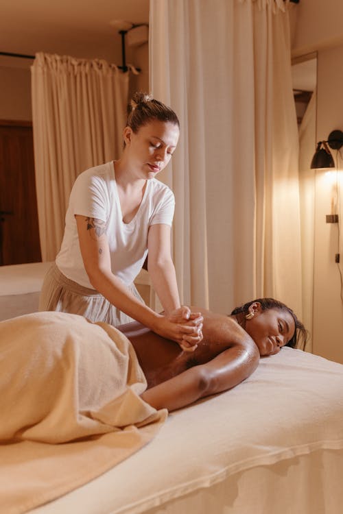 Free Woman Lying on a Massage Table and Getting a Massage  Stock Photo