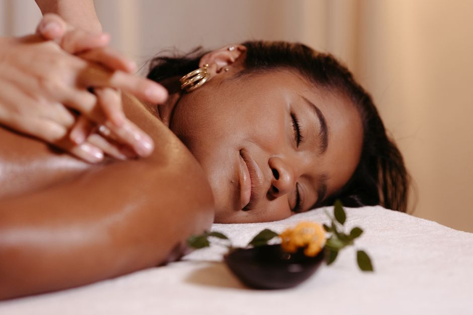 A woman with closed eyes enjoying a relaxing massage and aromatherapy treatment.