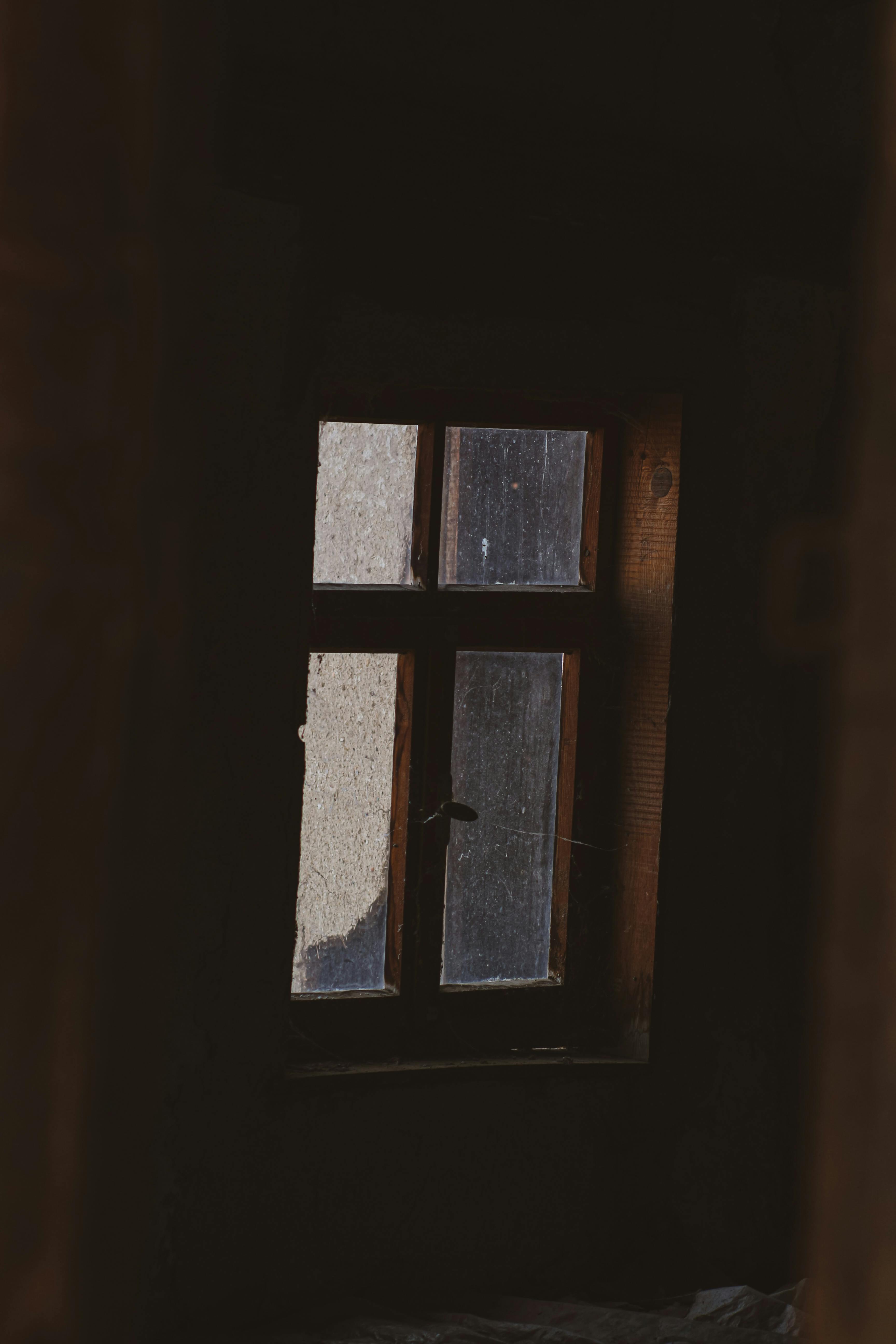 Free A vintage window in a dimly lit room evokes nostalgia and serenity. Stock Photo