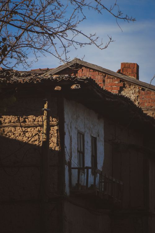 Free An old abandoned house with a rustic, weathered exterior under a clear blue sky in a rural setting. Stock Photo