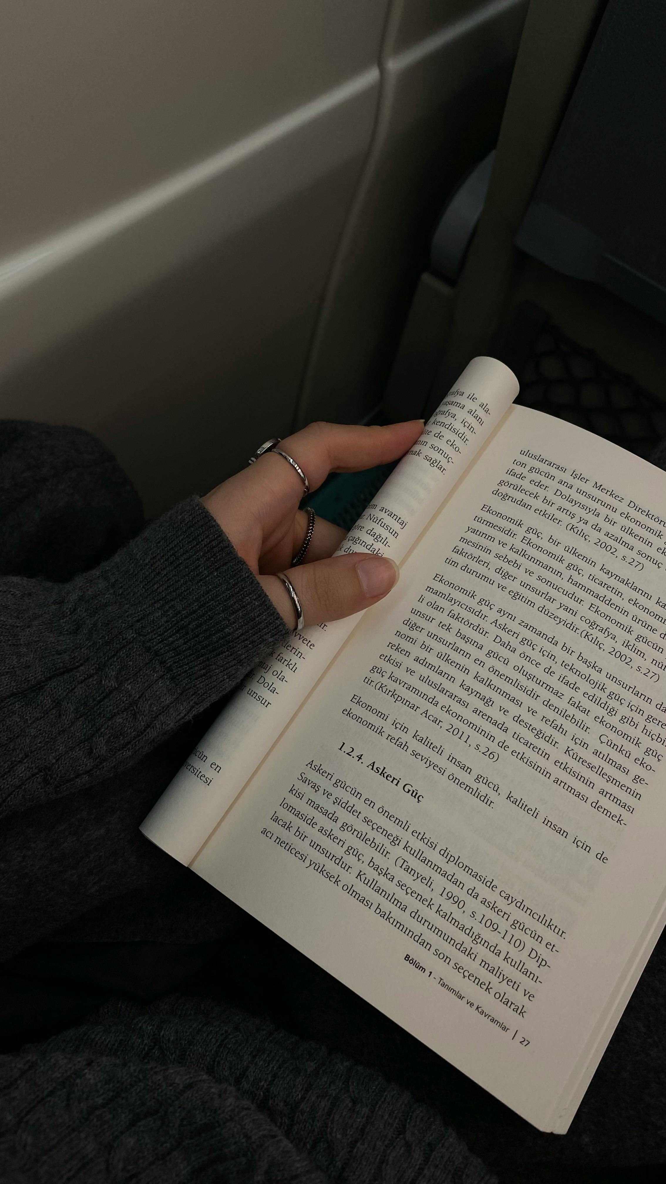 Close-up of a woman reading a book on a train in İstanbul, capturing a moment of quiet contemplation.
