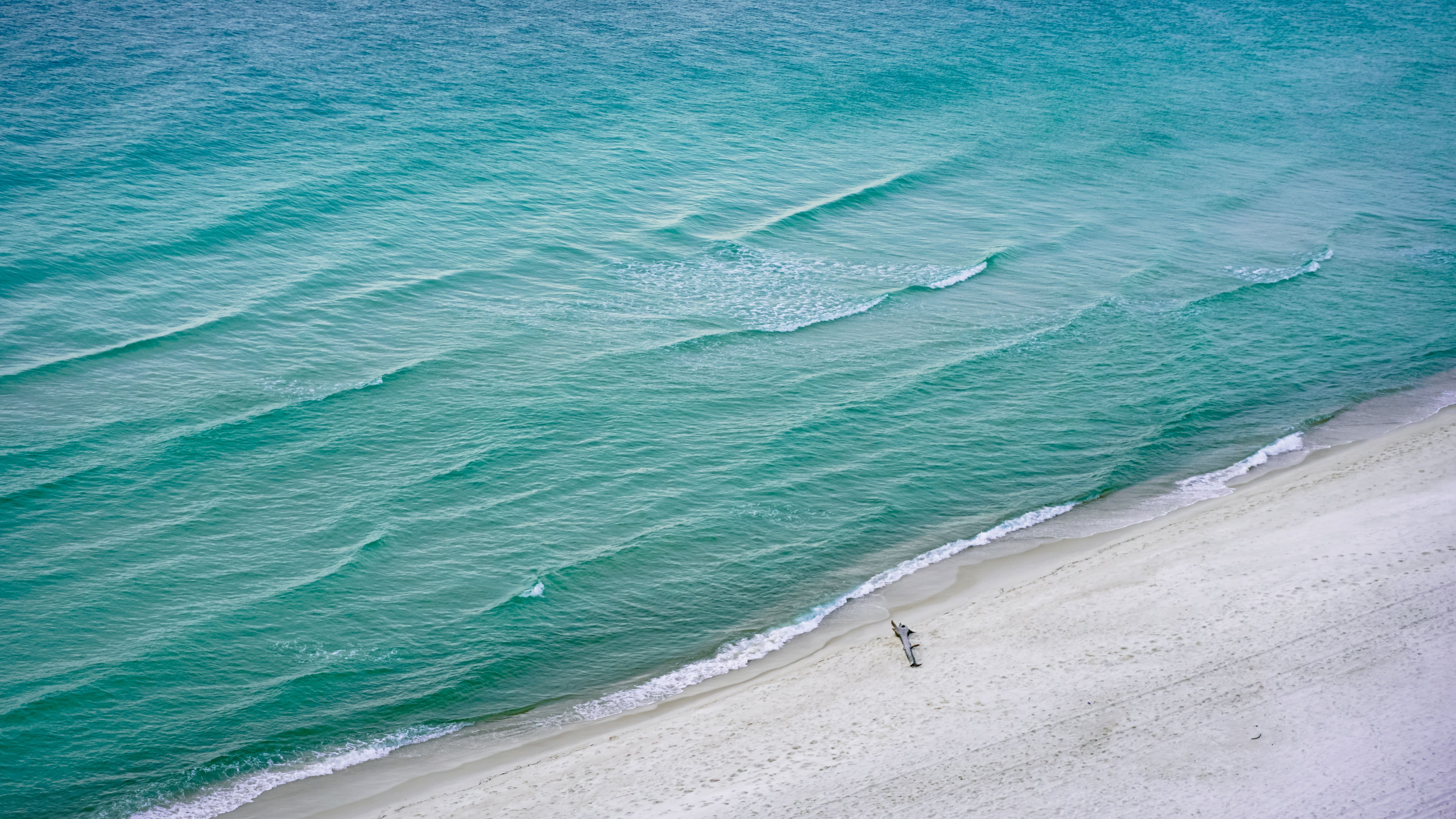 Aerial view of emerald green Gulf water and white sand beach on the Emerald Coast near Destin Florida