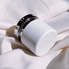 Plain white cream jar resting on soft ivory silk, photo by Absin on Pexels