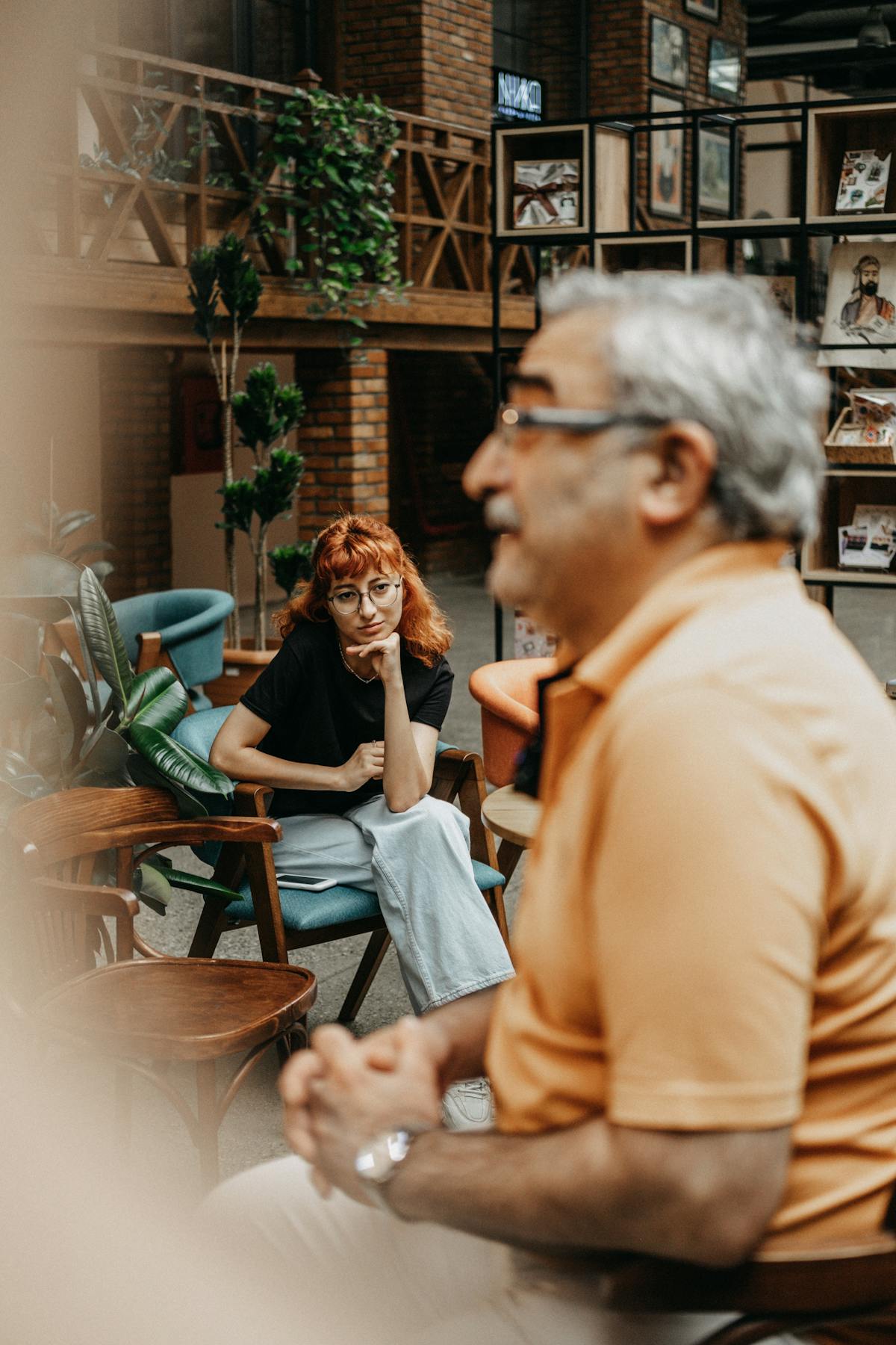 Uomo che parla con un'altra persona seduti a un tavolo del caffè