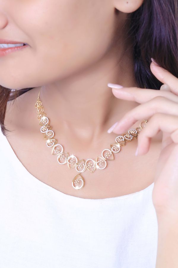 Model posing with an elegant gold pendant necklace