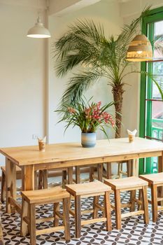 Bright and inviting restaurant interior featuring wooden furniture and lush plants, ideal for casual dining.