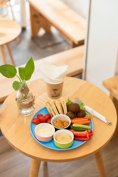 Free A colorful Middle Eastern breakfast featuring falafel, dips, and coffee on a wooden table. Stock Photo
