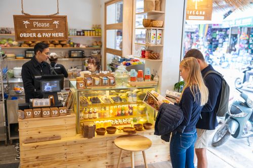 Free Cozy vegan cafe with diverse customers ordering at counter. Inviting and vibrant atmosphere. Stock Photo