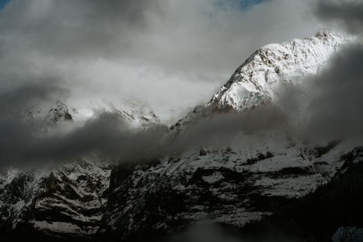 A snow covered mountain with clouds in the sky