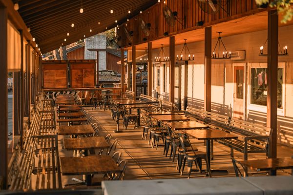 Warm outdoor patio with wooden tables and ambient lighting at a West LA restaurant
