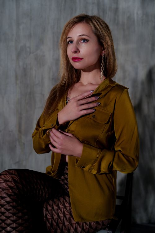 Free Portrait of an adult woman posing in a mustard blouse. Fashion concept. Stock Photo