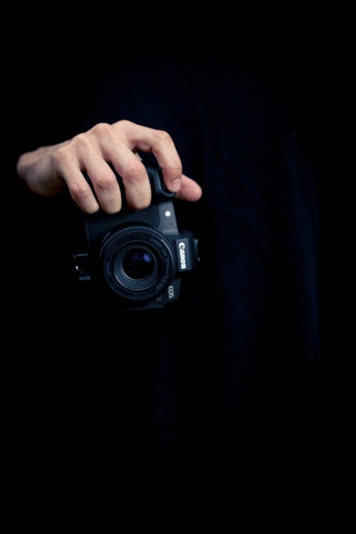 Close-up of a Man Holding a Canon Camera 