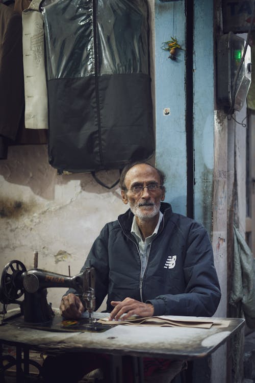 Elderly Tailor Using a Vintage Sewing Machine 