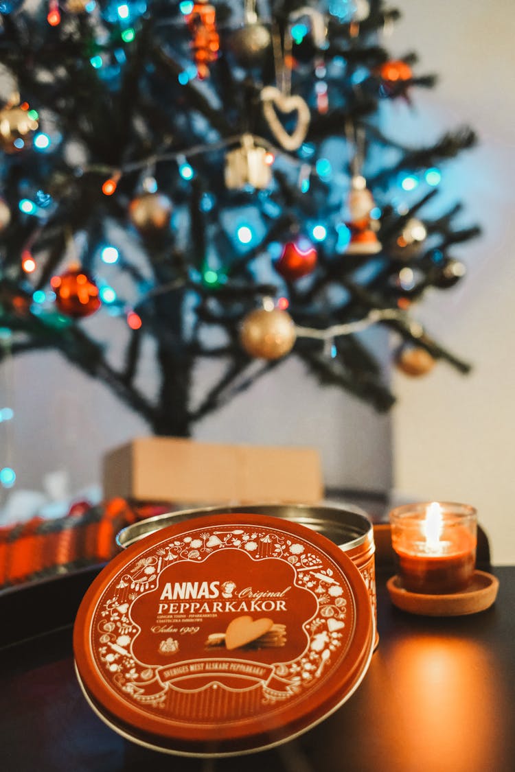 A Can With Cookies And A Candle On The Table On The Background Of A Christmas Tree