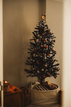 A beautifully decorated Christmas tree indoors with gifts and ornaments, creating a festive atmosphere.