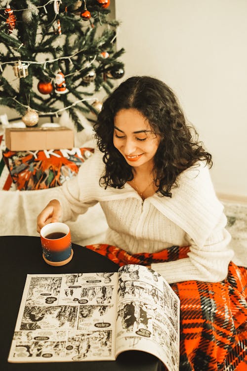 Woman with a Cup of Coffee Reading a Comic Book