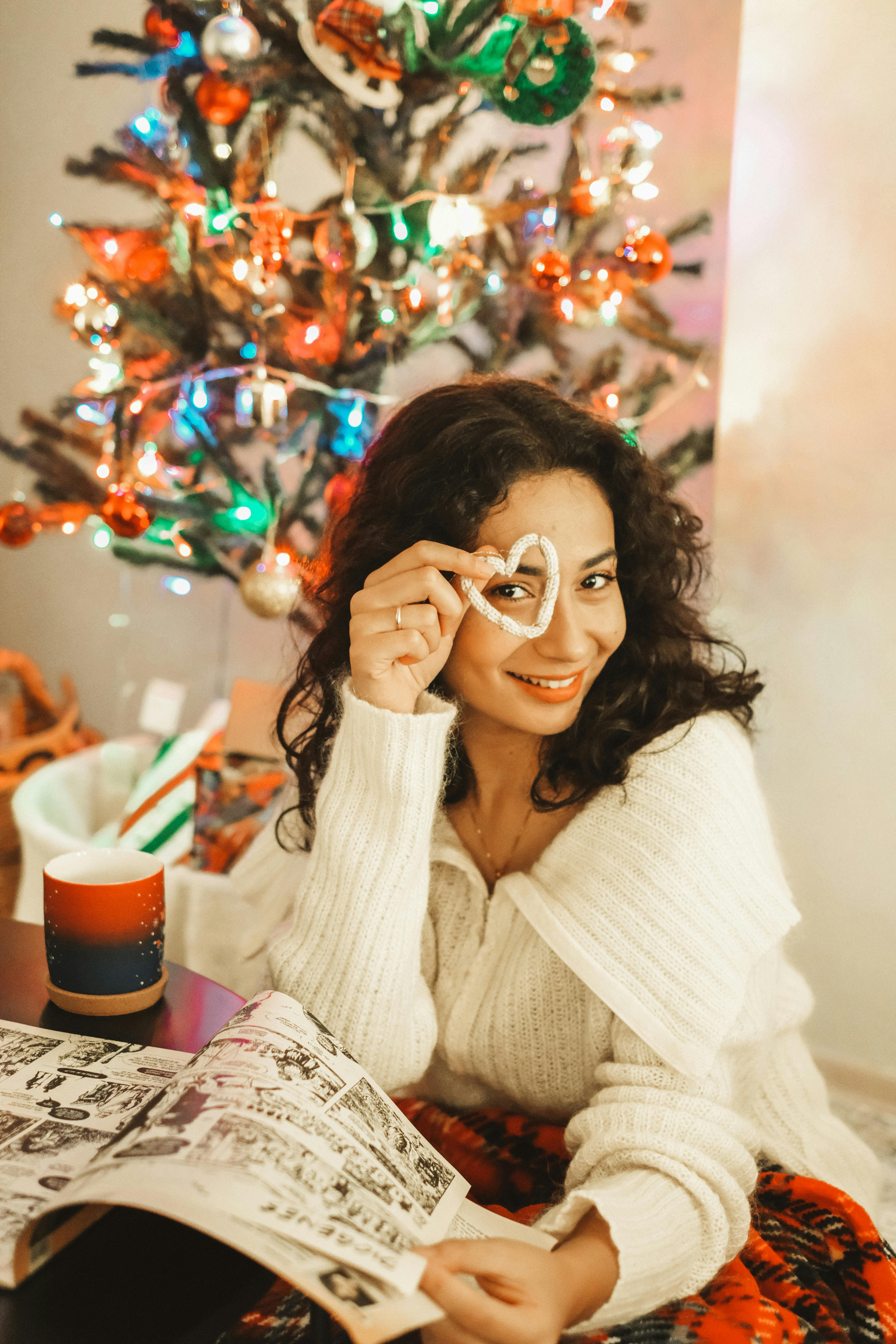 smiling brunette with magazine by christmas tree