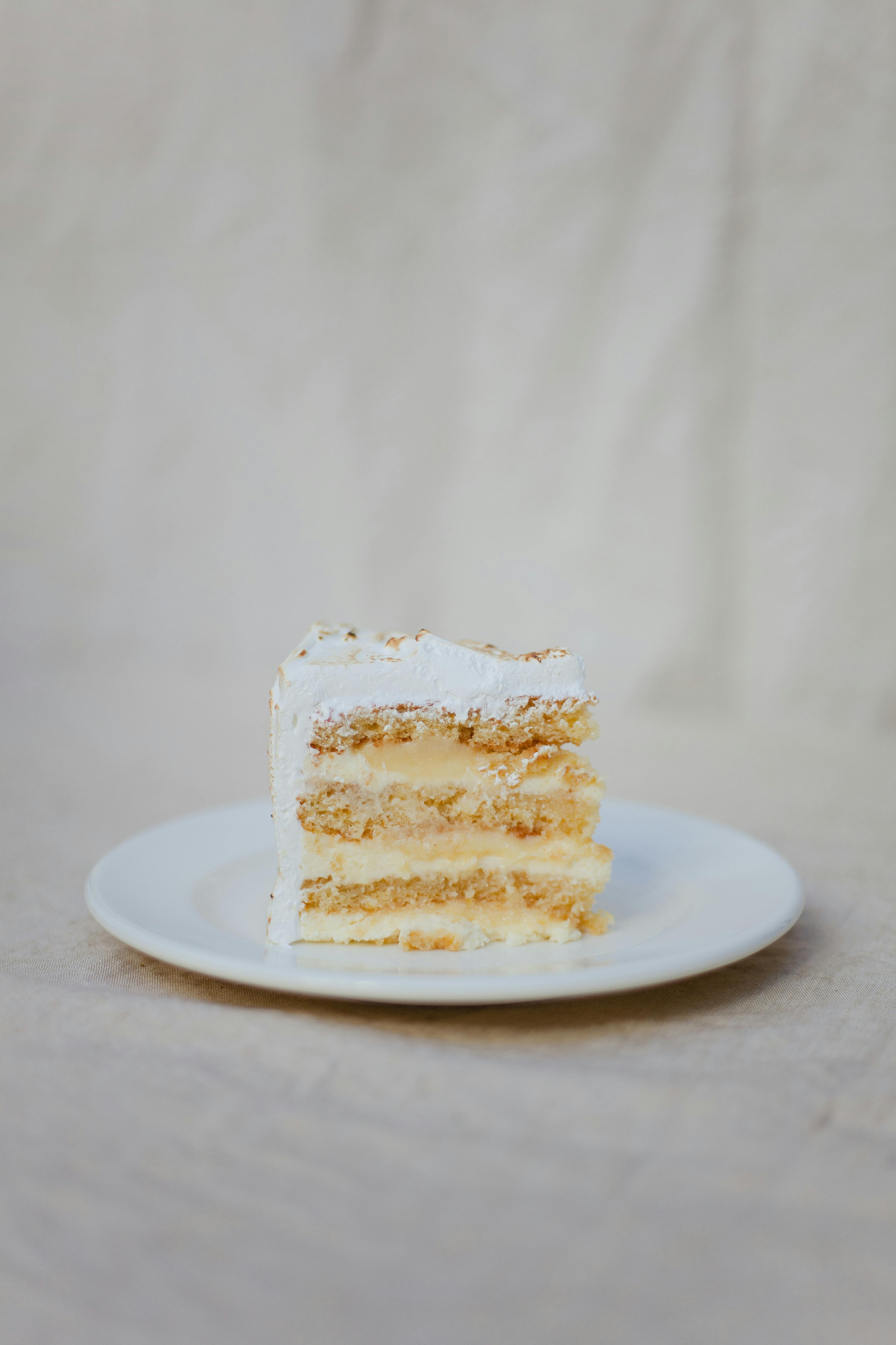 Delicious slice of layered cake with creamy filling on a white plate, perfect for dessert lovers.