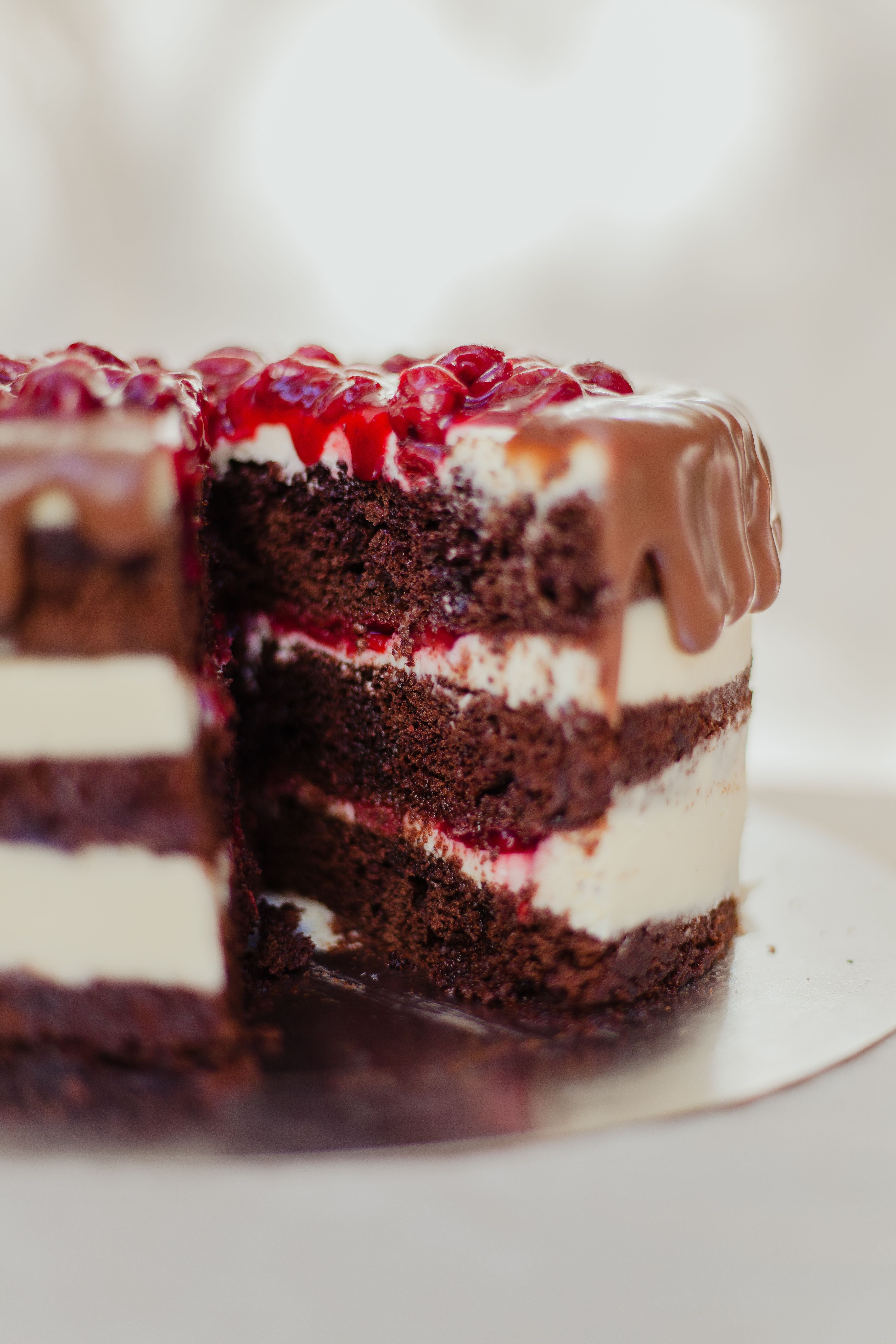 Indulge in a rich chocolate layer cake topped with berries and cream. Perfect for dessert lovers.