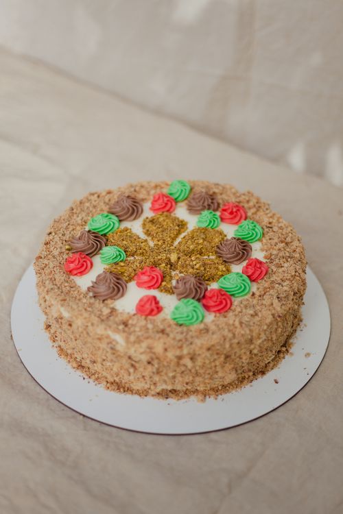 Free A delicious cake topped with colorful frosting and nuts, perfect for desserts and celebrations. Stock Photo
