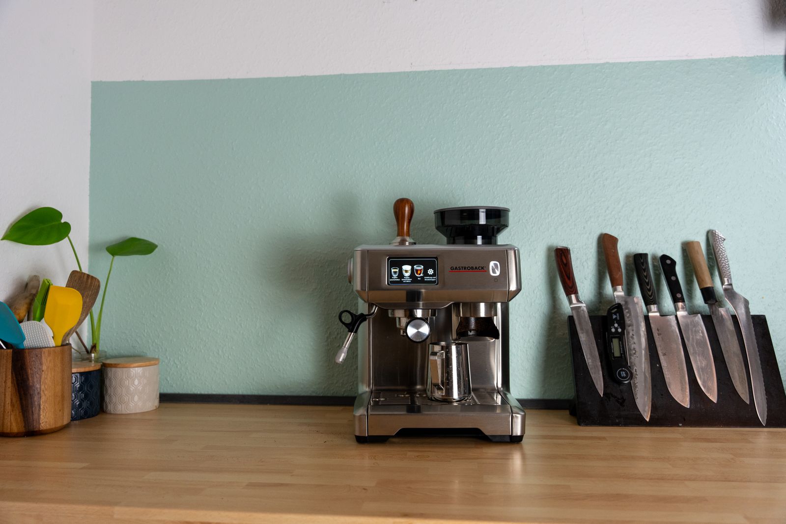 Espresso machine arranged on a bright kitchen countertop beside cooking utensils