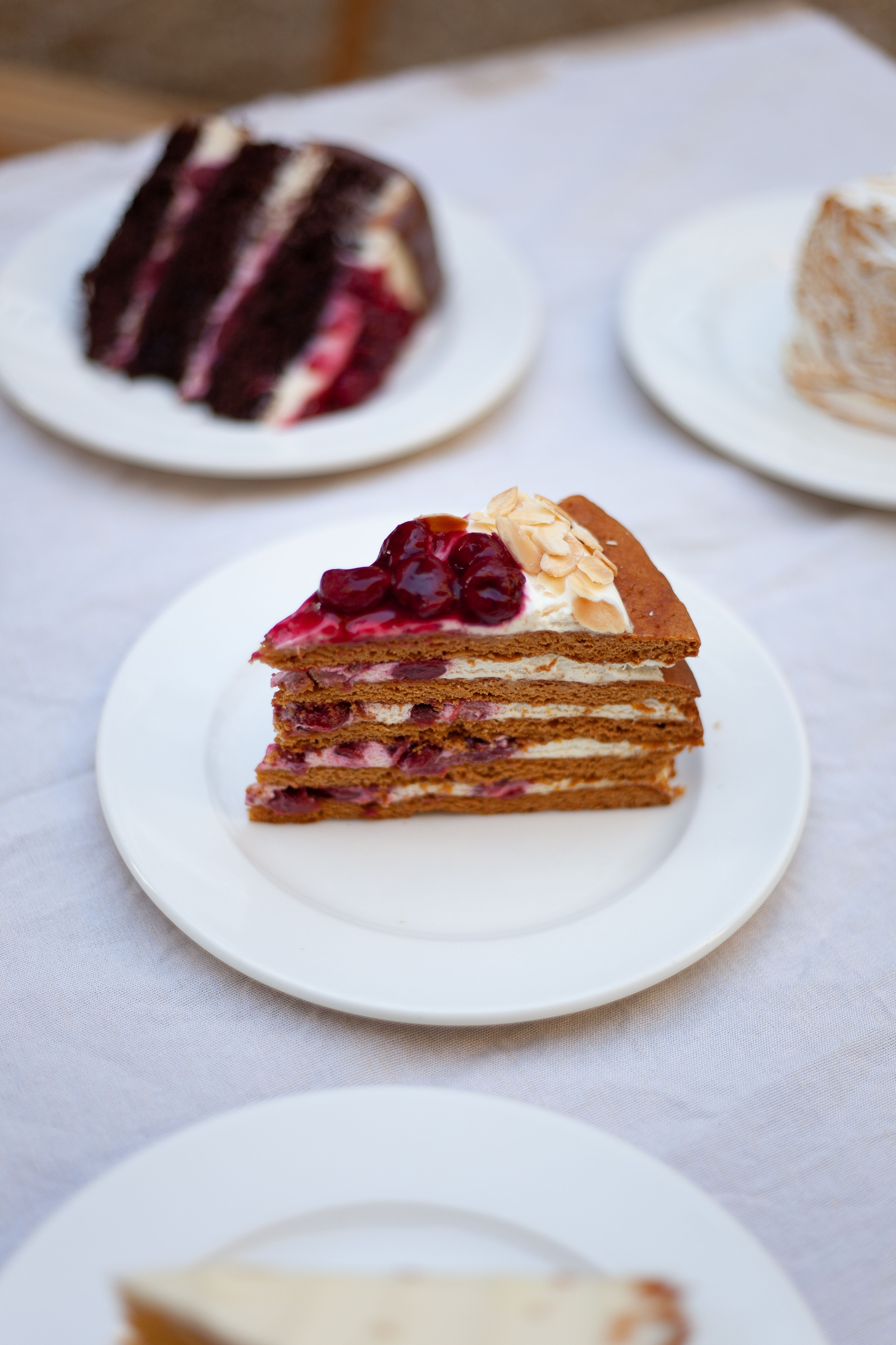 Slice of layered cake with berries and almonds, perfect dessert display for gourmet cuisine.