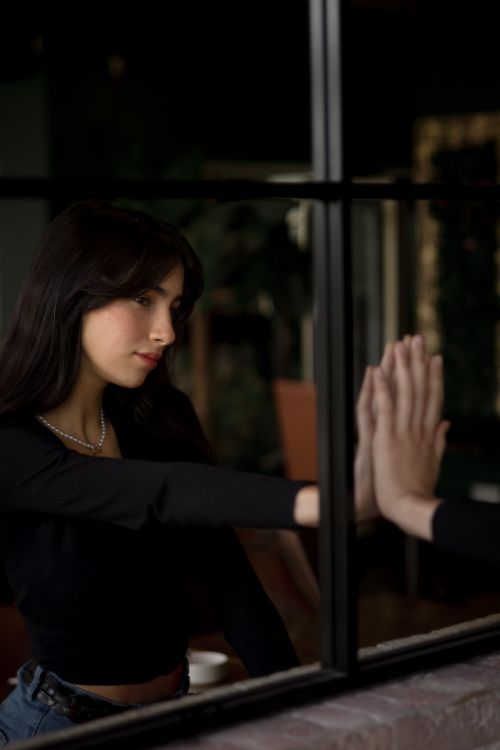 Woman touching a reflection in a mirror