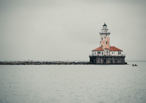 Free Serene view of the historic Chicago Harbor Lighthouse under overcast skies on Lake Michigan. Stock Photo