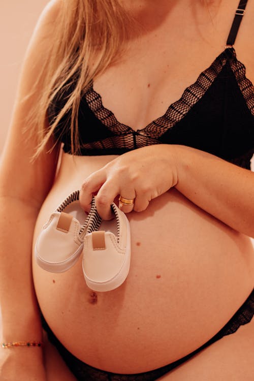Beautiful Pregnant Woman Holding Baby Shoes