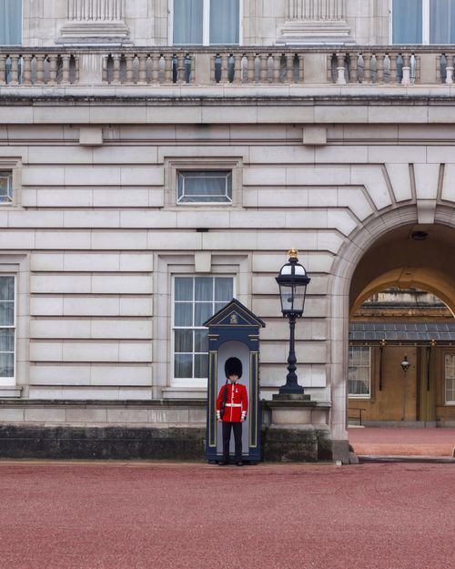 Free Iconic view of a royal guard in traditional uniform at Buckingham Palace, London, England. Stock Photo