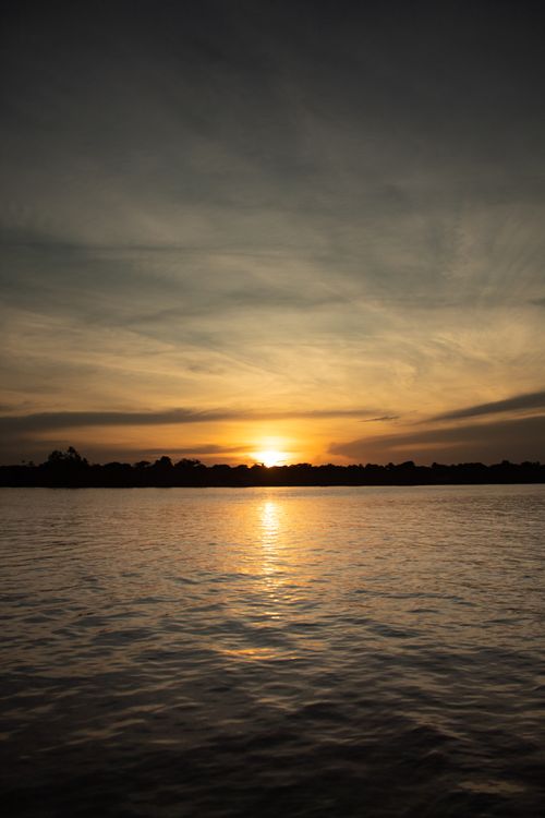 Free Beautiful sunset over a calm river in Breves, Brazil, with a serene sky. Stock Photo