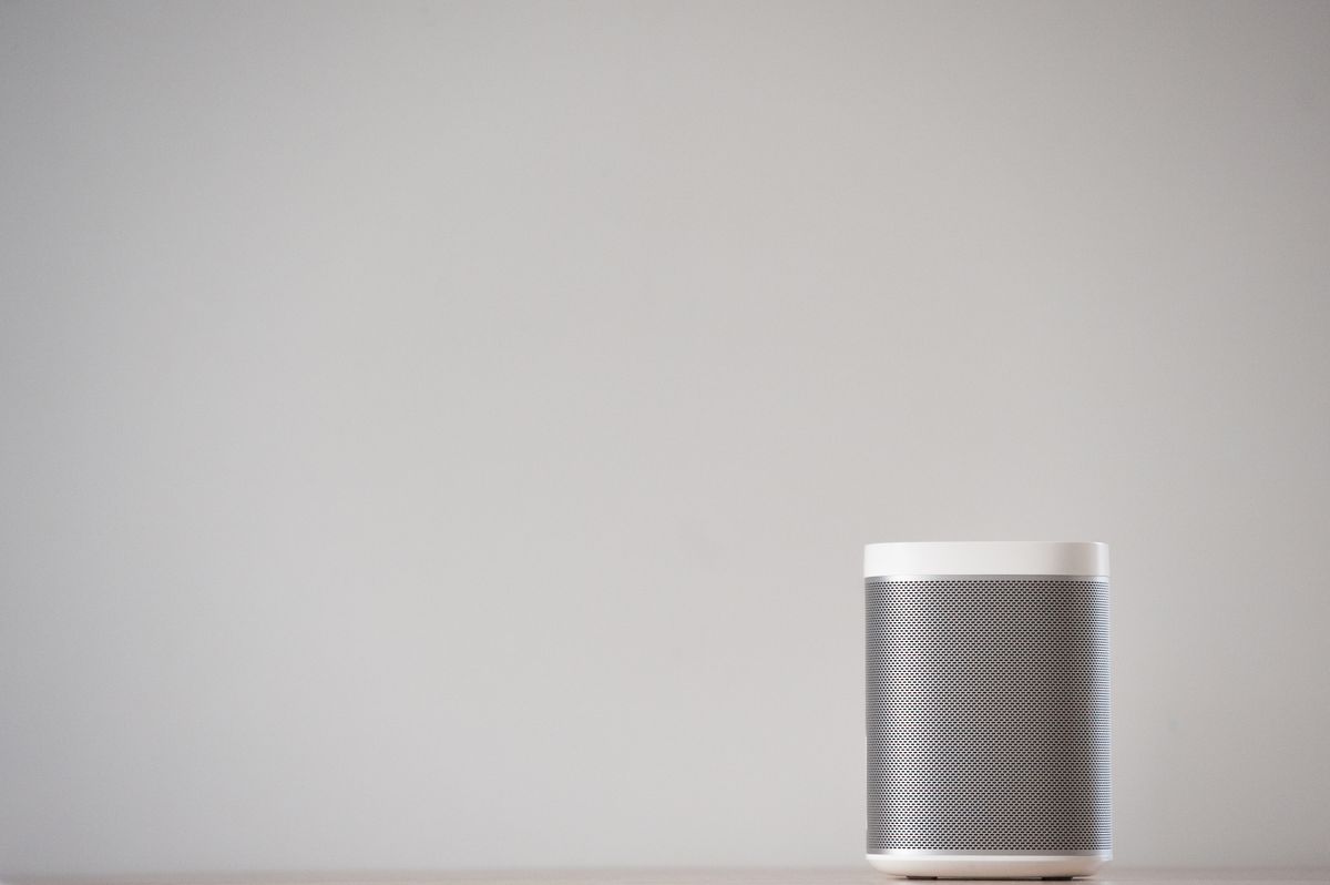 Sleek wireless smart speaker on a wooden table in a modern home