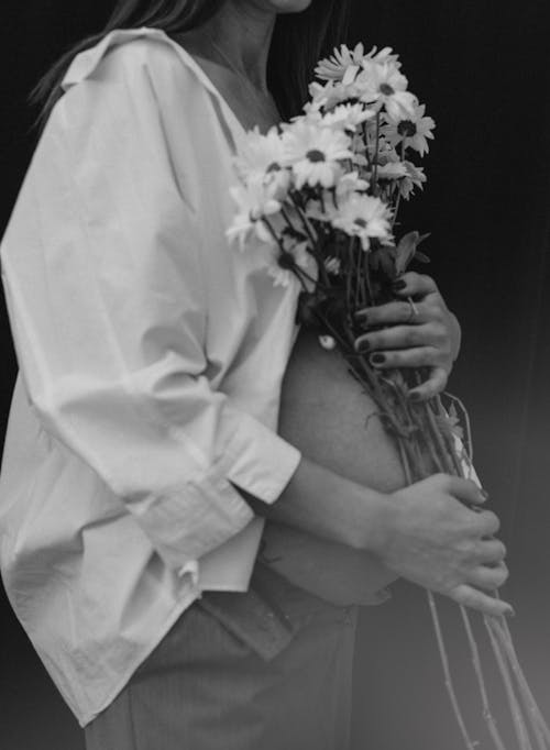 Pregnant Woman Touching Belly with Flowers