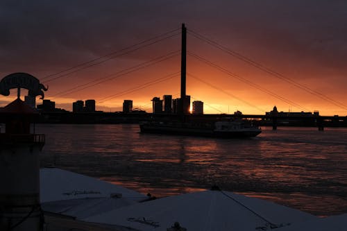 Bridge and a Ship Sailing on the Sea at Sunset