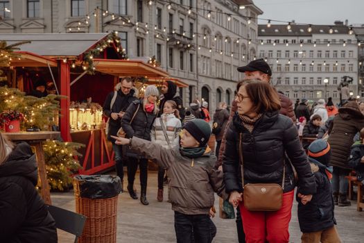 Family strolls through a festive Christmas market in Zürich, capturing the joy of the winter holidays.
