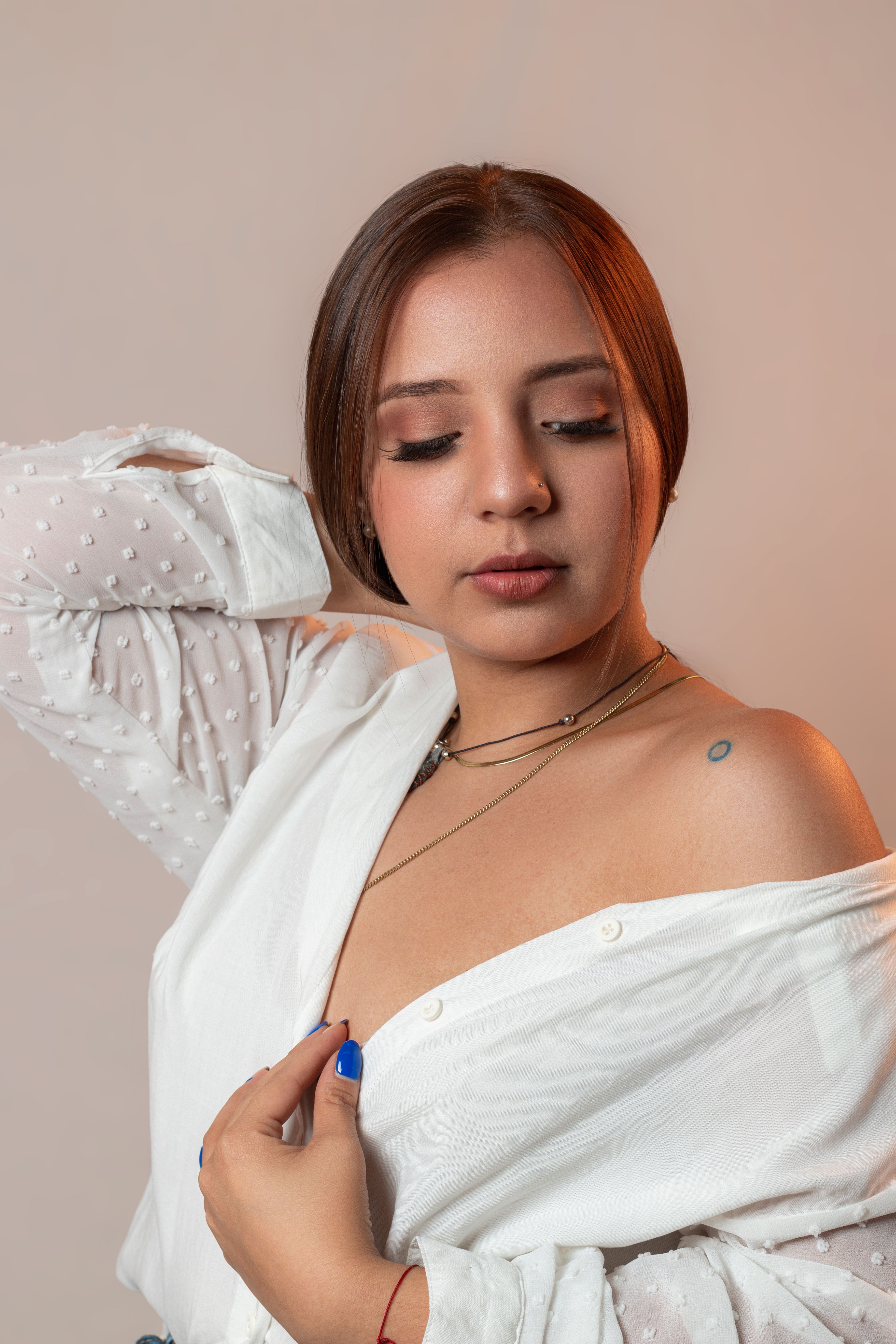 Portrait of a woman in a white blouse with soft lighting and warm tones.
