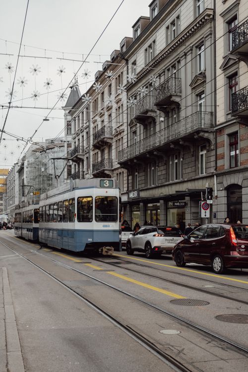 Free Tram number 3 navigating the busy streets of downtown Zurich with classic European architecture in the background. Stock Photo