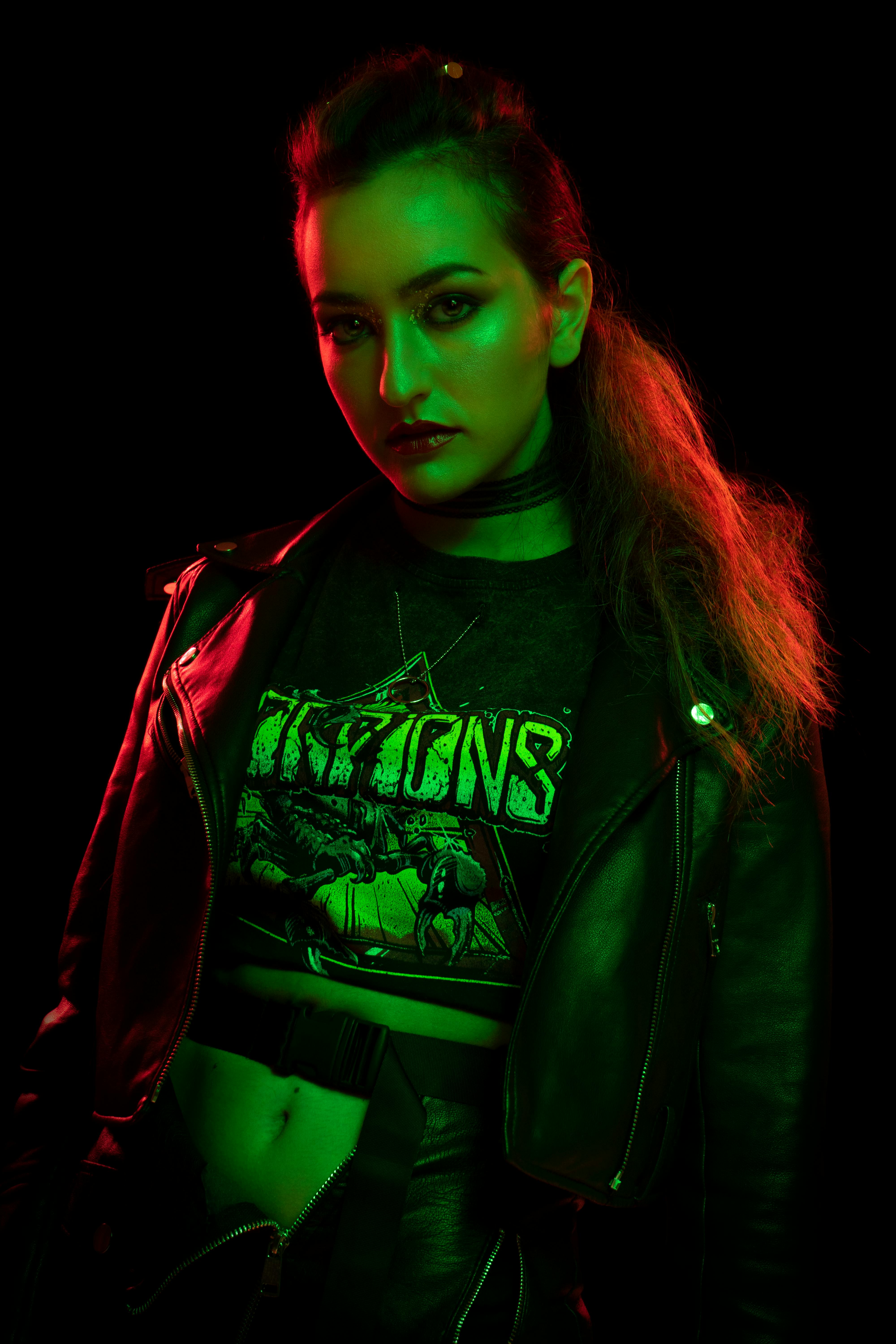 a woman in a leather jacket and green neon lights