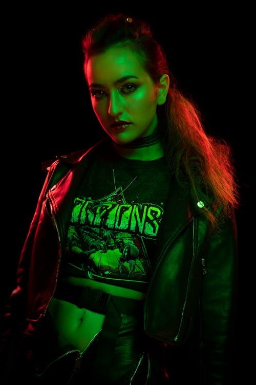 A woman in a leather jacket and green neon lights
