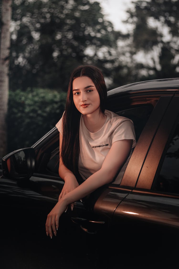 Woman Leaning Out Of Window Of Car