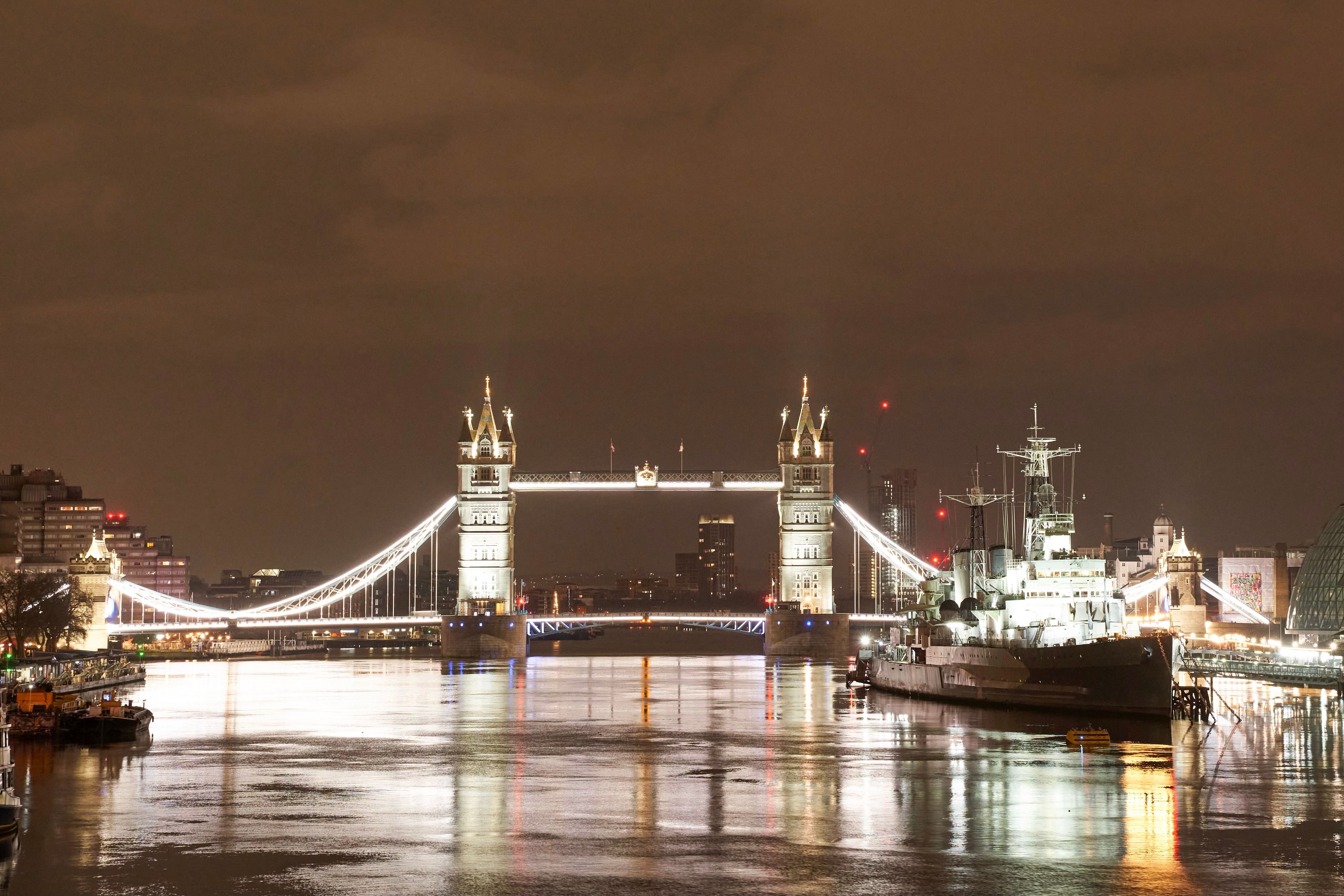 Night view of the illuminated Tower Bridge and HMS Belfast on the Thames in London.