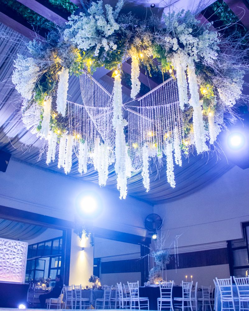 Venue with illuminated floral ceiling installation and elegant seating